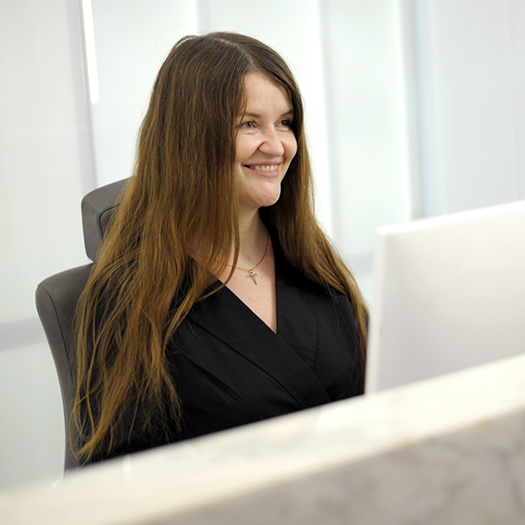 Smiling woman sitting at dental office front desk
