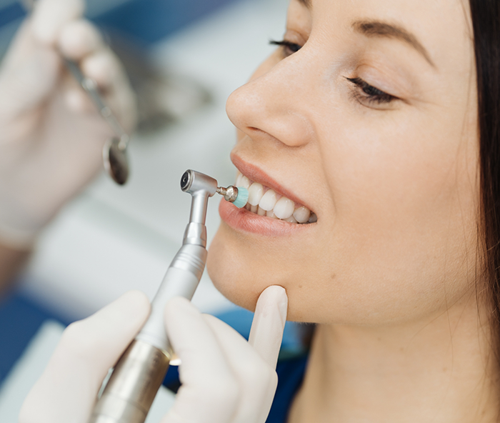 Female dental patient having teeth polished