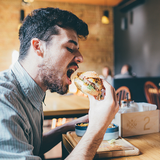 Bearded man about to take a bite of a sandwich