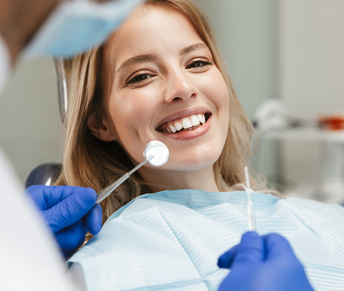 Blonde woman sitting in dental chair smiling