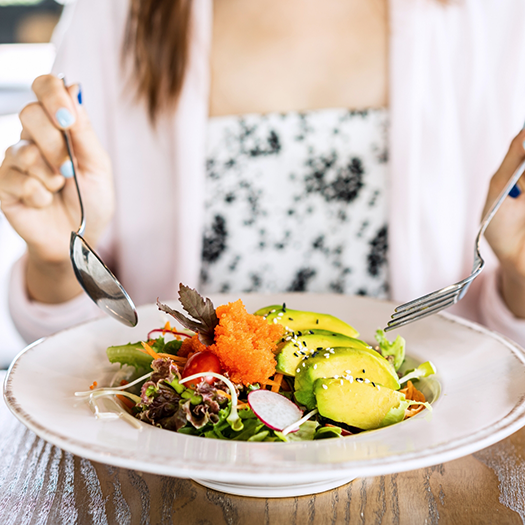 Eating a salad with a fork and spoon