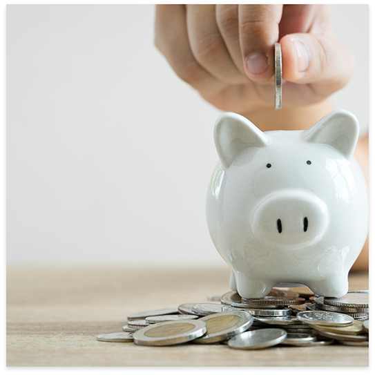 Putting coin in piggy bank surrounded by other coins